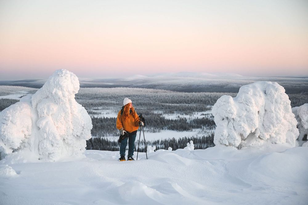 Lumikenkäilijä tunturissa iltavalossa